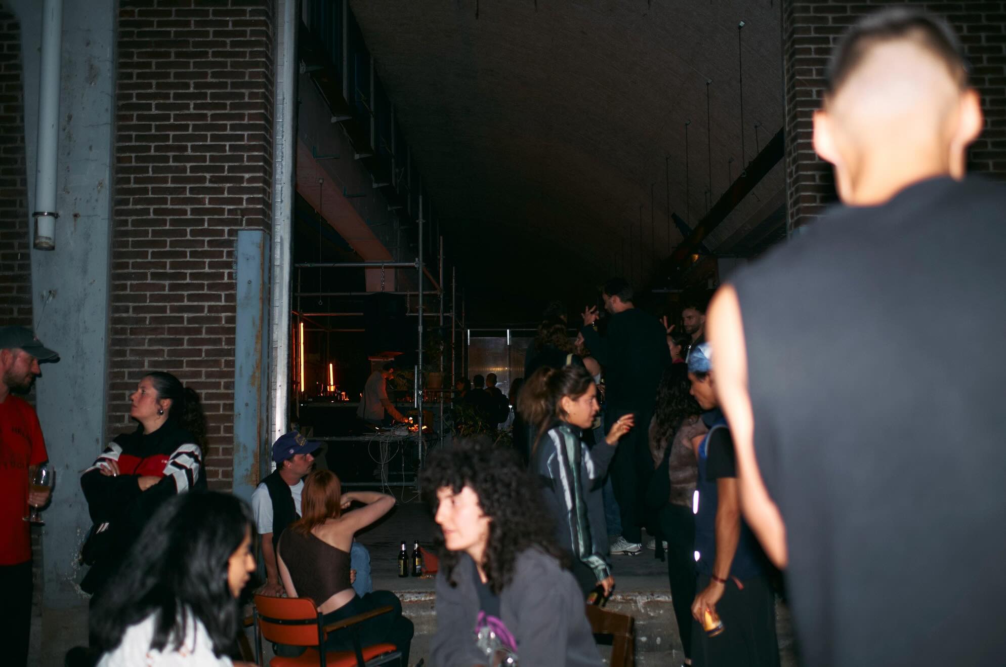 People gathered under the brick arches at Filth during an evening event